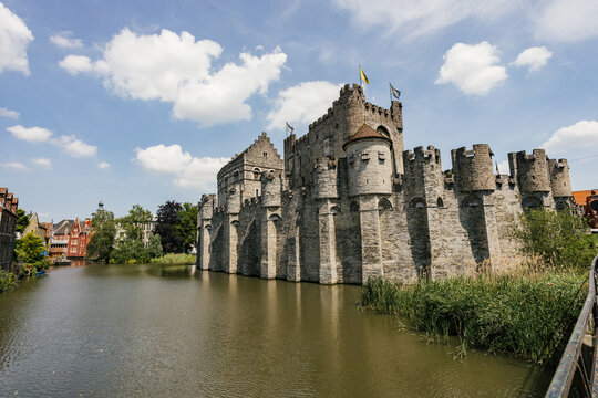 Historic Castle Stands by Tranquil Waterway on a Sunny Day