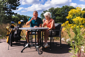 Senior Couple Reviewing Scores at a Golf Course Table