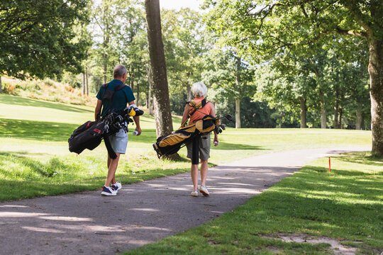 Senior Couple Walking Together on a Golf Course Path