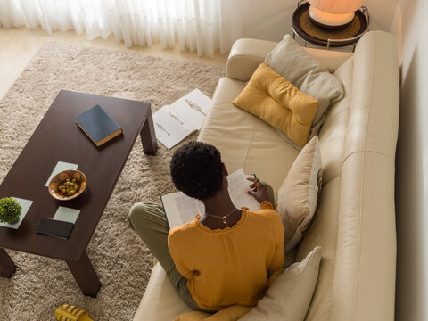 Anonymous woman reading book at home
