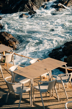 Dining Setup by the Ocean Waves on a Sunny Day