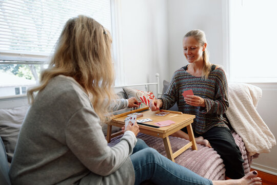 Woman enjoying card game with friend in cozy and relaxed home se