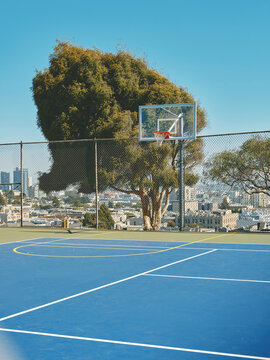 Basketball Court With City Skyline and Greenery in the Background