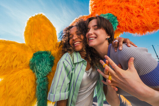 Two happy young women embracing at outdoor event