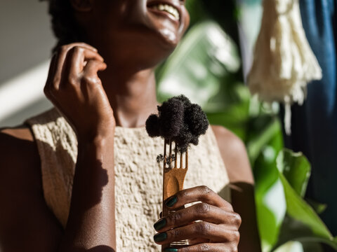 Woman holds flock of hair on comb