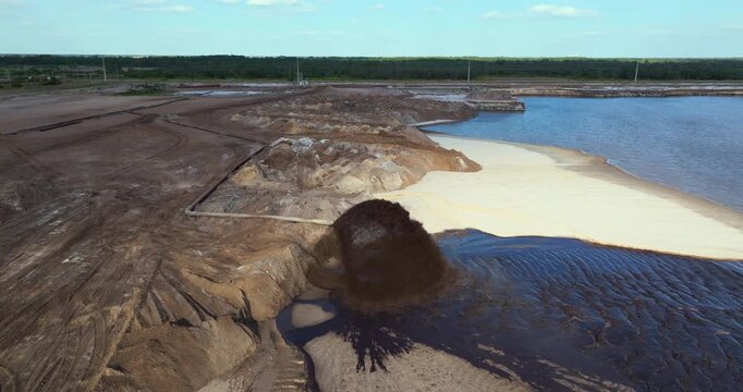 Active phosphate mine in Florida with slurry pipeline transporting water, clay and sand from dredging pit.