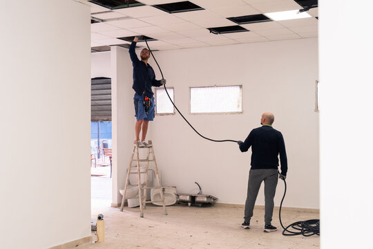 Men installing new wiring at office