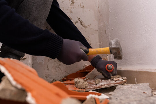 Worker deconstructing old walls