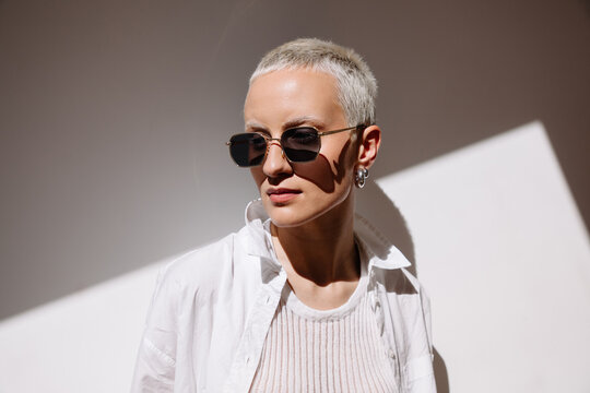 Blonde woman with short platinum hair wearing sunglasses