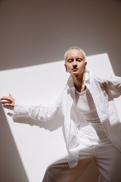 Female Model poses in white attire with shadow patterns