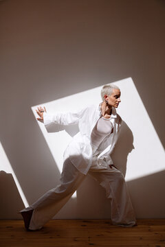 Dynamic pose of a stylish individual in a bright space