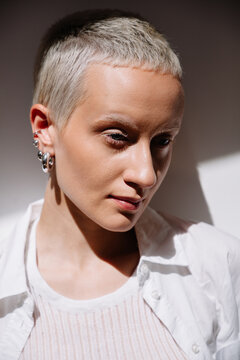 Portrait of a young person with short hair and earrings