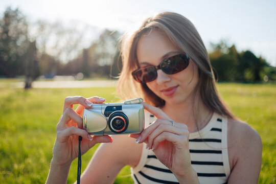 Taking photos on point and shoot film camera in a sunlit park