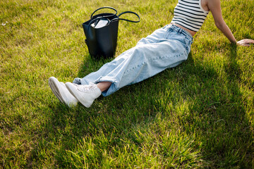 Relaxing on the grass in denim jeans with a casual style