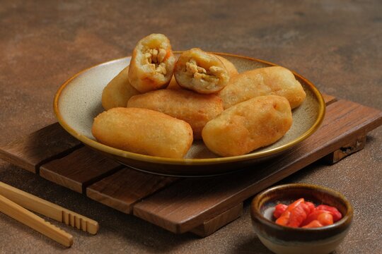 Combro, savoury snack on plate. Combro, traditional food made from grated cassava which is shaped round or oval and filled with oncom or tempeh , chili sauce then fried. Fried mashed cassava filled
