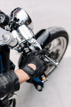 Motorcycle rider gripping throttle with leather gloves