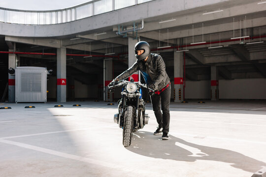 Rider prepares to start motorcycle in parking garage