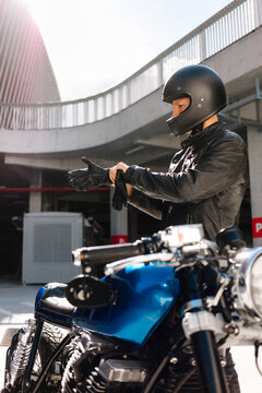 Motorcyclist prepares for ride in urban setting during sunny day