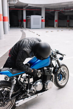 Motorcycle rider prepares to start engine in modern parking