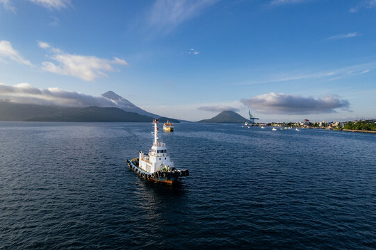 Tugboat in harbour with volcano in background