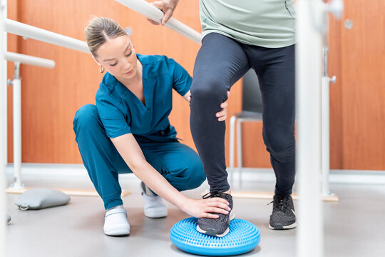 Physiotherapist assisting patient with balance training exercise