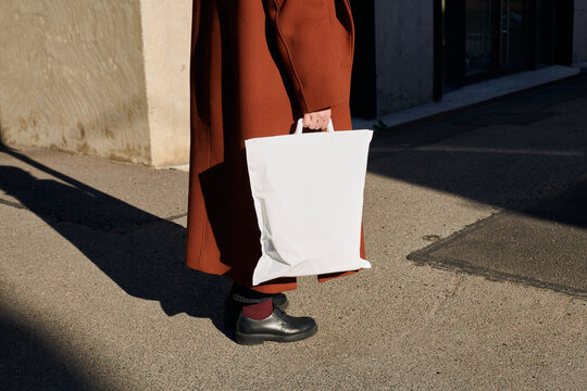 Person walks with a thermal bag along a sunlit city street