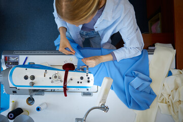 Expert seamstress crafting detailed blue textiles