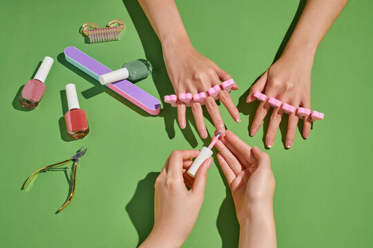 A person's hands are getting a manicure, complete with nail polish