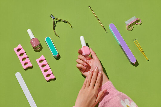 Manicure tools arranged on a vibrant green surface