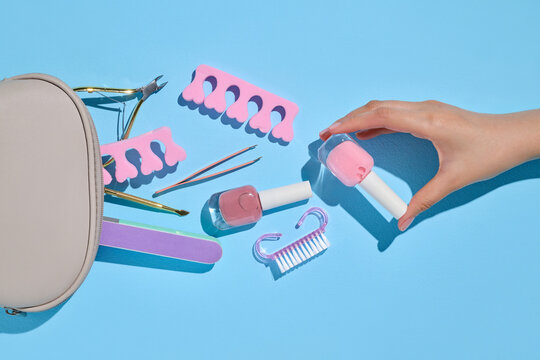 Nail care essentials: nail polish, tools, and a hand on a bottle