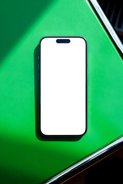 phone Mockup with White Screen on Green Table Sunlit Setting