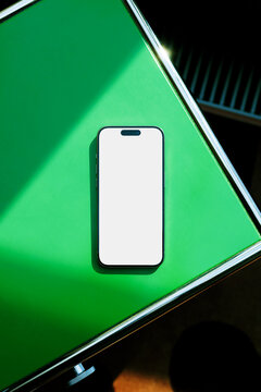 phone Mockup with White Screen on Green Table