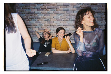 Friends enjoying karaoke at a lively bar on a weekend night