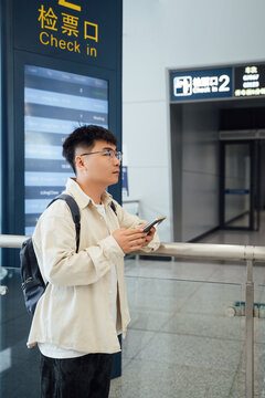 Asian man using mobile phone in train waiting room