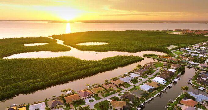 Evening light over Florida waterfront community. Expensive homes and luxury mansions illuminated by sundown sky.
