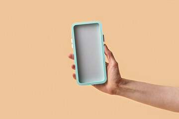 Hand presenting papercraft phone on peach background
