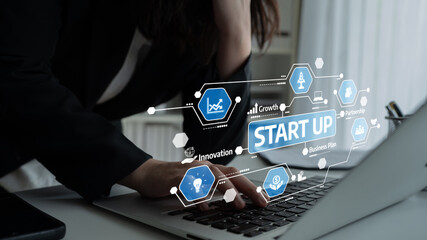 A focused entrepreneur works on a laptop, with digital graphics showcasing startup growth metrics and business innovation strategies in a modern office space. Tessel