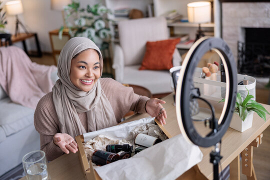 Content creator showing off beauty products haul during live stream
