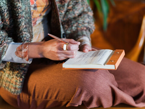 Person Writing Notes in Notepad