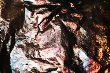 Foil with Colorful Reflections. Shimmering foil background. Folds and folds of multicolored foil.Textured Abstract Wrinkled Foil . Glittery multicolored mockup. Copy space