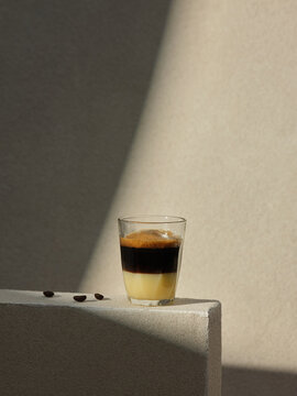 A glass of layered Vietnamese coffee with coffee beans