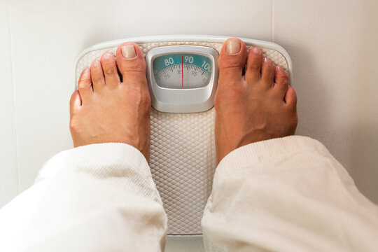 Person Standing on Scale in Bathroom for Weight Measurement