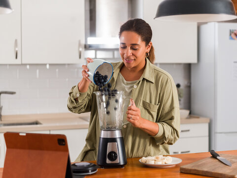 Woman making blueberry smoothie 