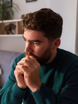 Man in Blue Sweater Deep in Thought at Home