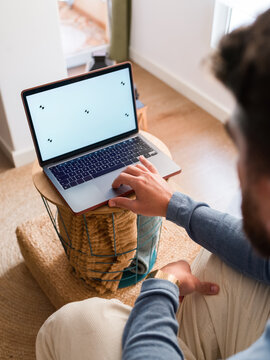 Person working on laptop with blank screen 
