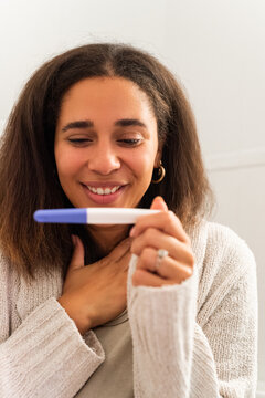 Excited woman happy to see pregnancy test results