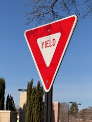 Red and white triangular yield traffic safety sign with a shallow depth of field 