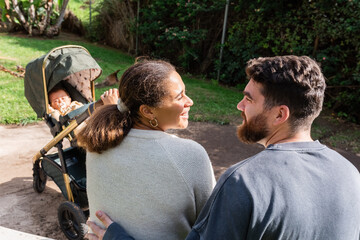 Couple Enjoying a Sunny Day With Their Baby in a Stroller