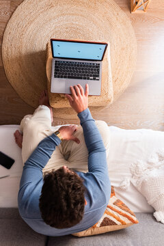 Man Working on Laptop at Home in Cozy Living Room