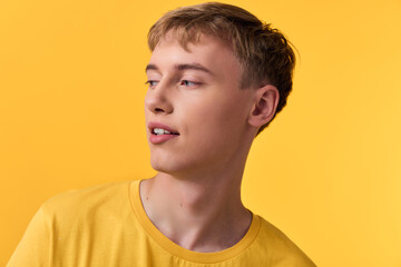 Obraz premium Man in a bright yellow shirt against a matching studio background, relaxed pose and subtle smile, fashion oriented mood with warm lighting and minimal clutter for lifestyle and product use
